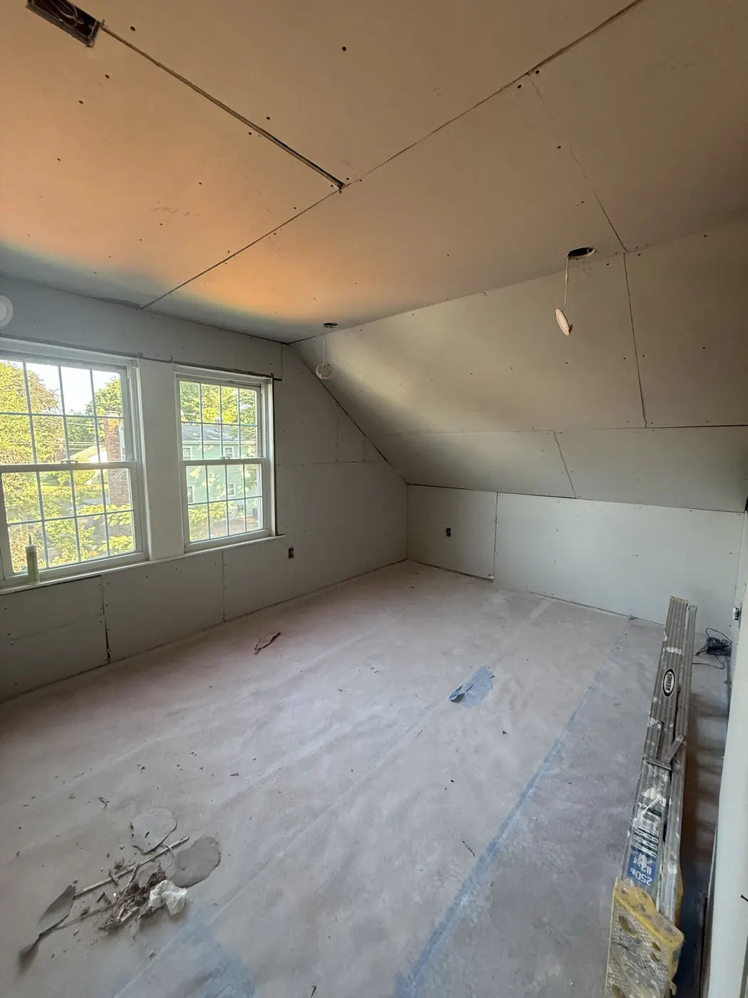 FG Professional Services project: attic room with new drywall on the walls and sloped ceiling