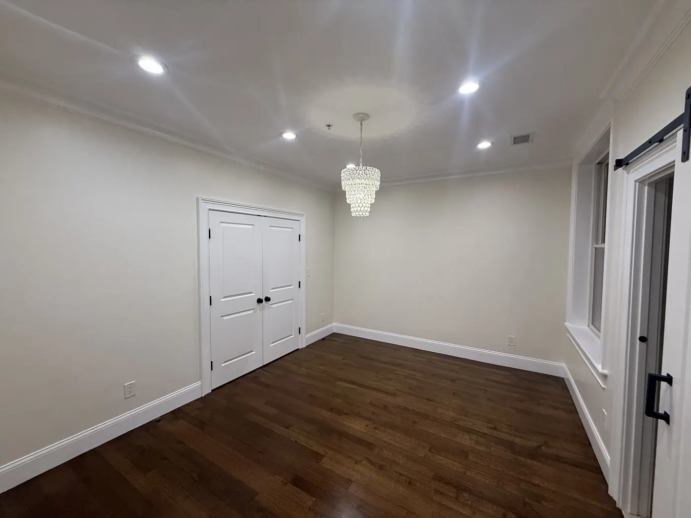 Dining room with white walls, crown molding, and double doors