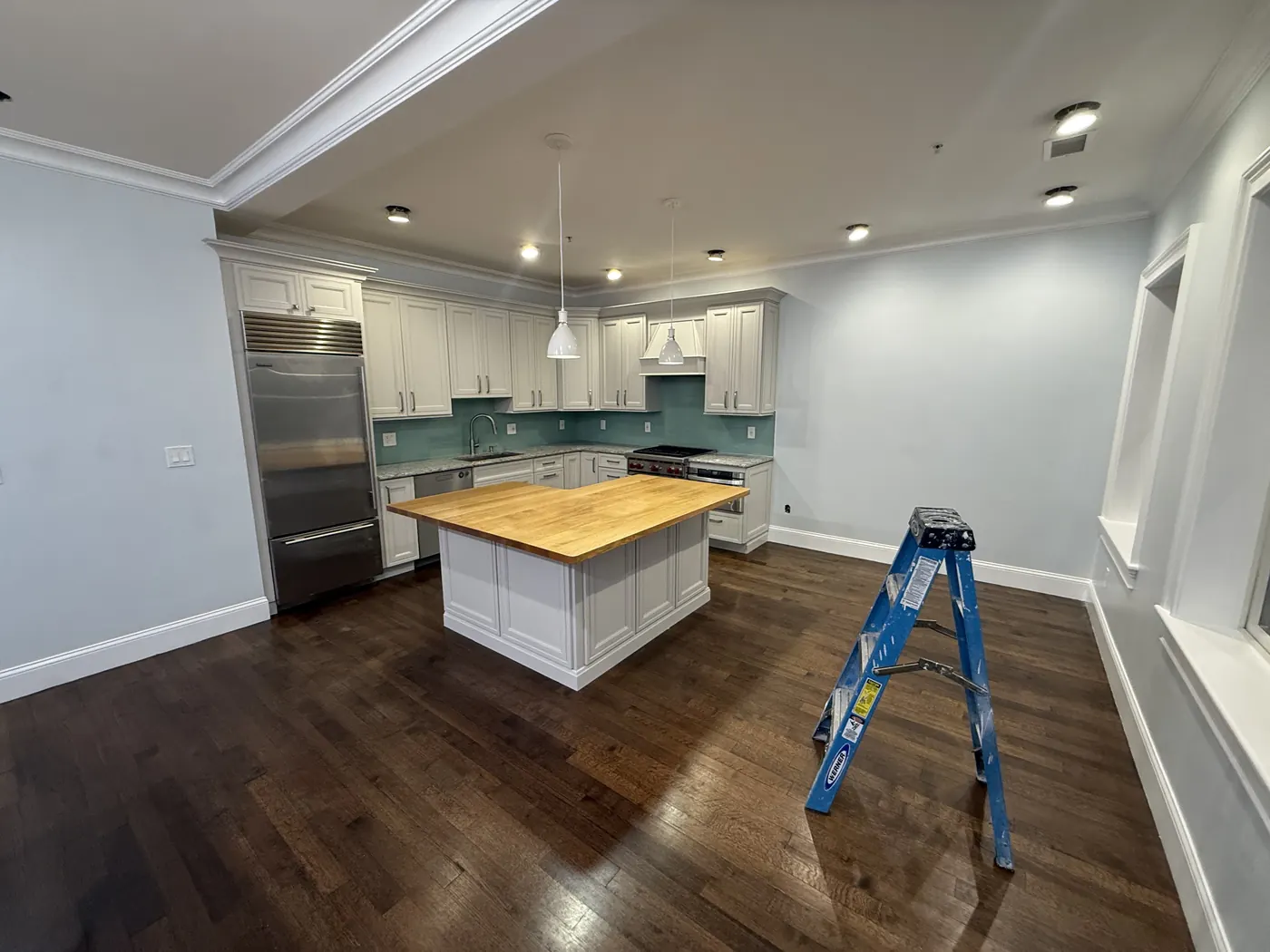 Open kitchen with white cabinets and a butcher-block island