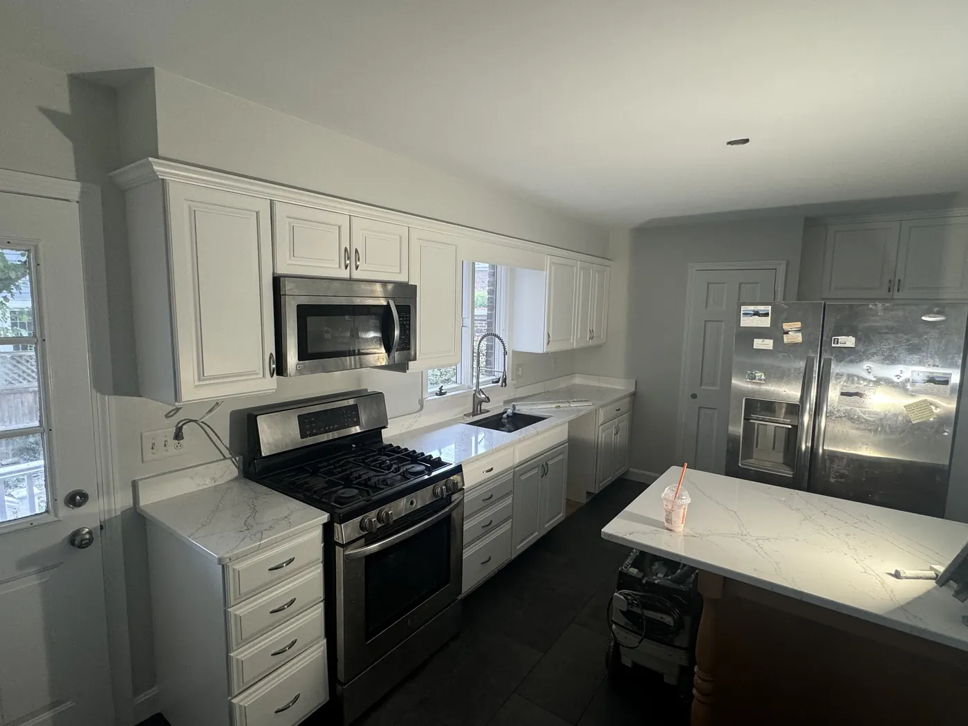 White kitchen cabinets and island seen from the side door