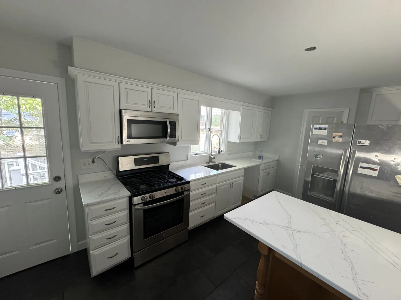 FG Professional Services project: kitchen with white cabinets, stainless appliances, and marble-look counters